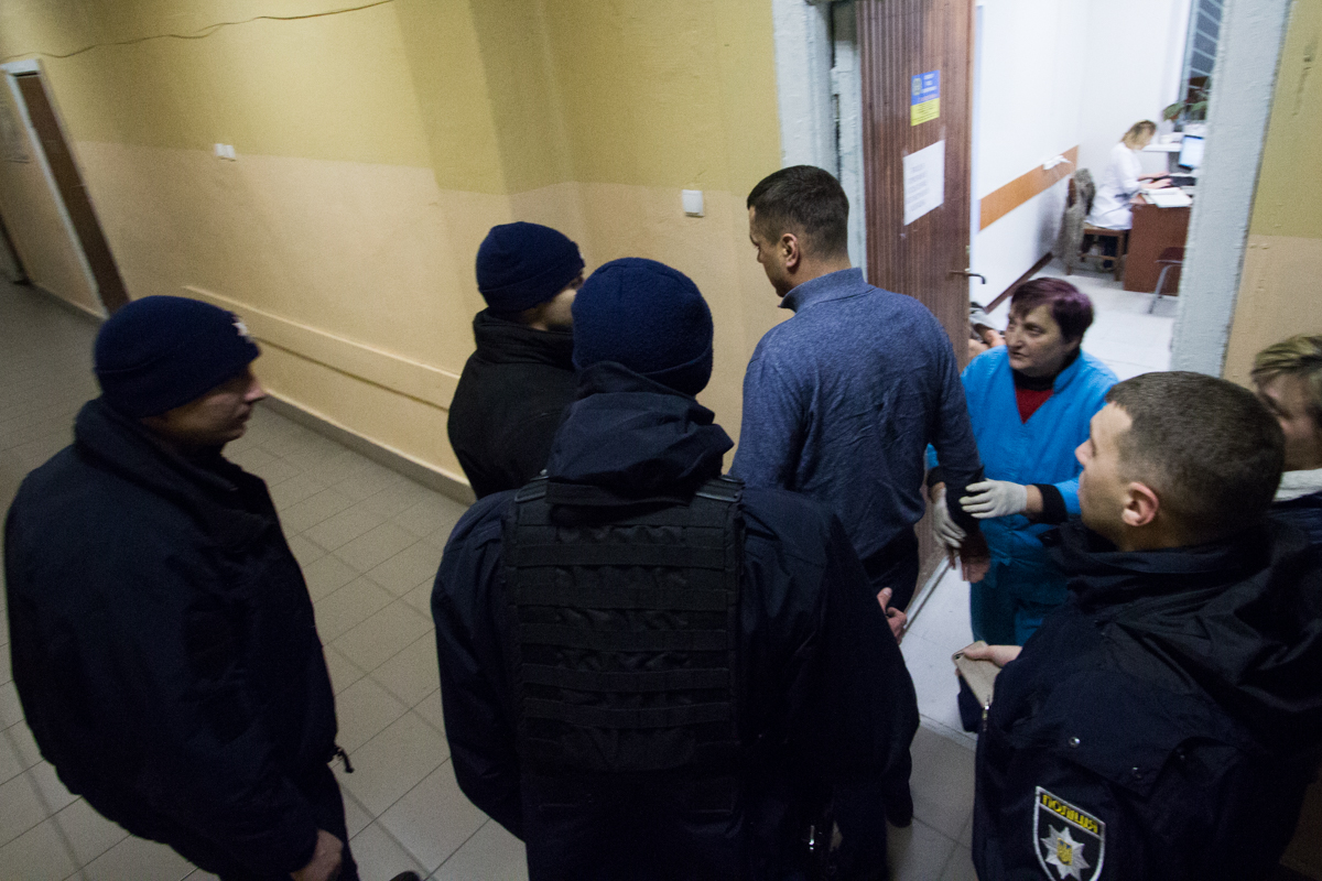 Патрульная полиция вместе с медперсоналом контролируют передвижение стрелка, начавшего приходить в себя